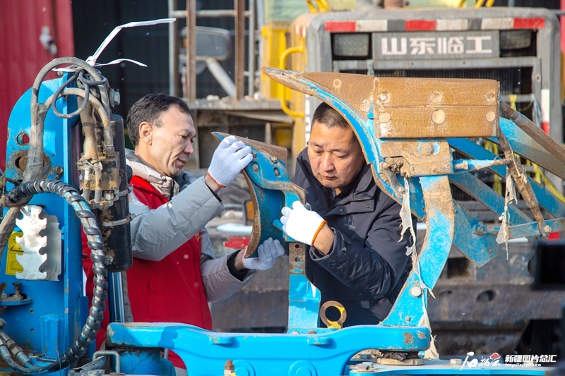 博尔塔拉蒙古自治州精河县八家户农场的农技人员（左）帮农户调试农机，助力春耕生产。（来源：王兴玉提供）